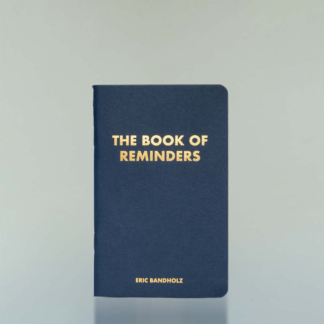 The Book of Reminders by Eric Bandholz against a grey background.